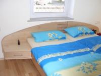 Doppelbett aus Holz mit Nachttisch